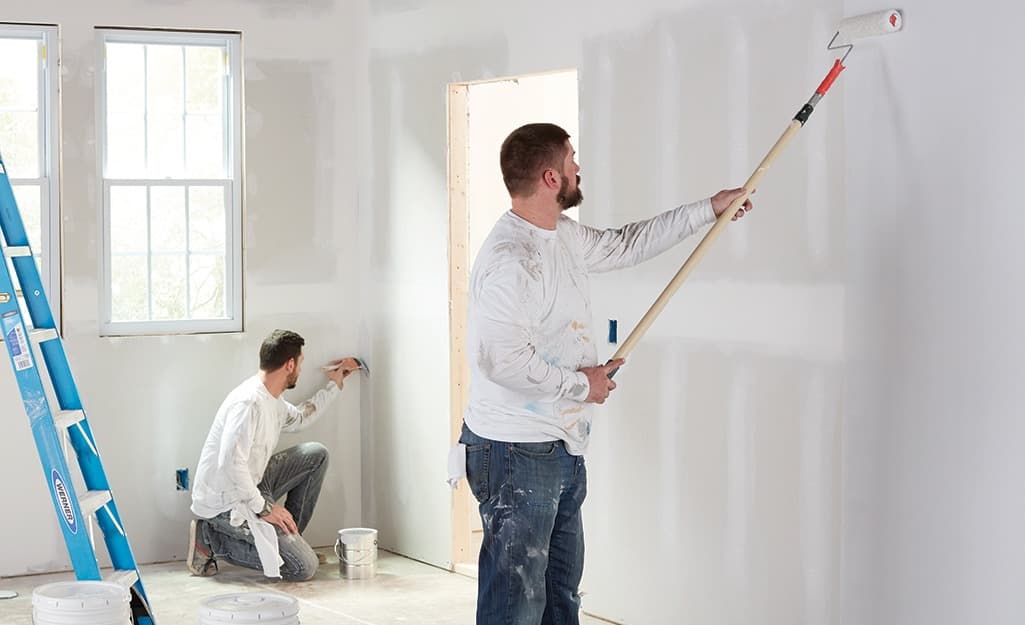 Paint roller applying fresh coat on an interior wall